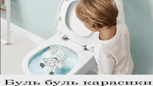 a child is looking at a toilet with a drawing of a man in a chair on it