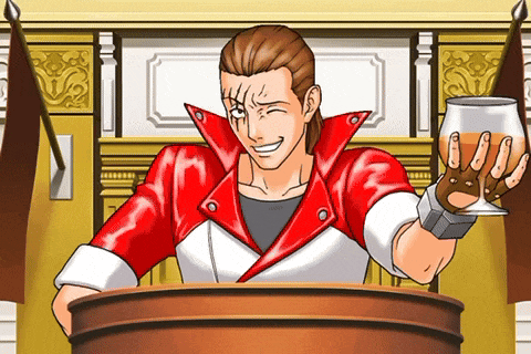 a man in a red jacket is giving a speech while holding a glass