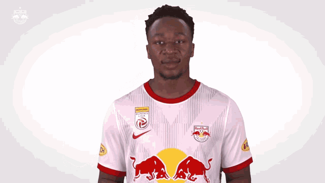 a man wearing a white jersey with red bulls on the front