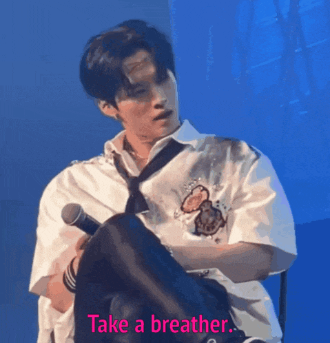 a man holding a microphone with the words take a breather written below him