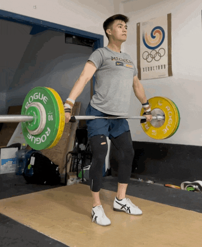 a man lifting a barbell with a rogue barbell