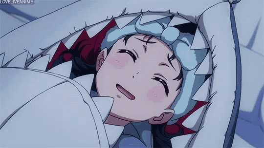a girl in a shark costume is smiling and laying in bed