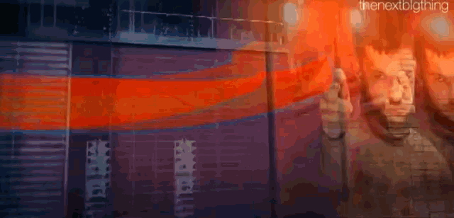 a blurry picture of a man standing in front of a building with the words " the next big thing " on the bottom