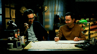 two men are sitting at a desk with a green lamp and the words " delusionalforharmony " on the bottom right