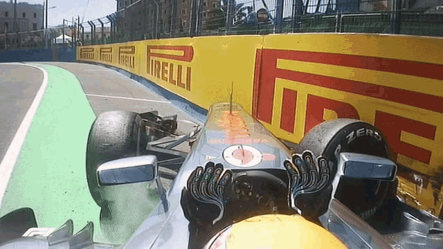 a race car is on a track with a yellow wall that says irelli on it