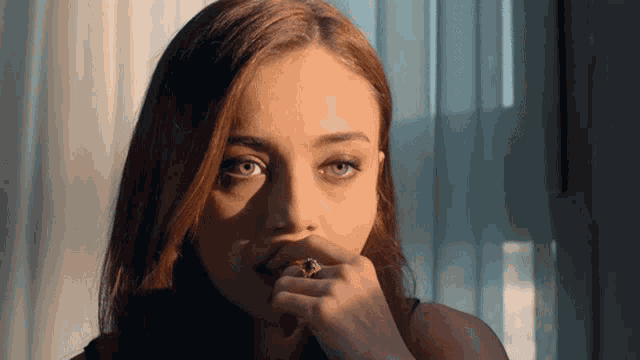 a woman with a ring on her finger is looking at the camera