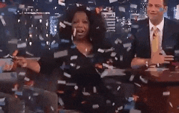 a woman is standing in front of a man in a suit and tie while confetti is falling around her .