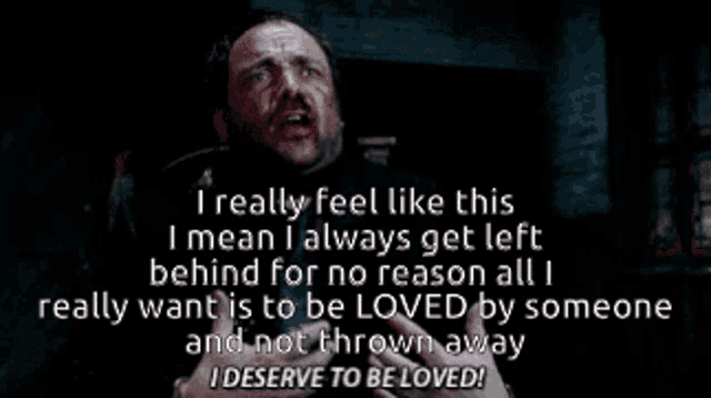 a man with a beard is screaming in a dark room with a quote behind him .