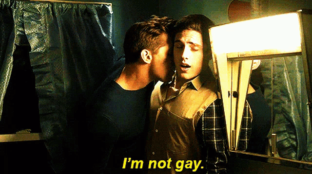 a man kissing another man on the cheek with the words i 'm not gay in yellow letters