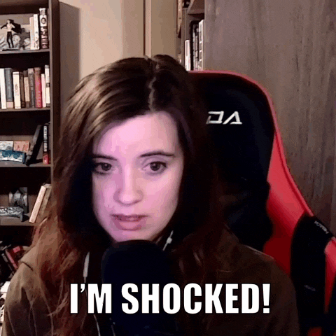 a woman sitting in a chair with the words " i 'm shocked " written on her face
