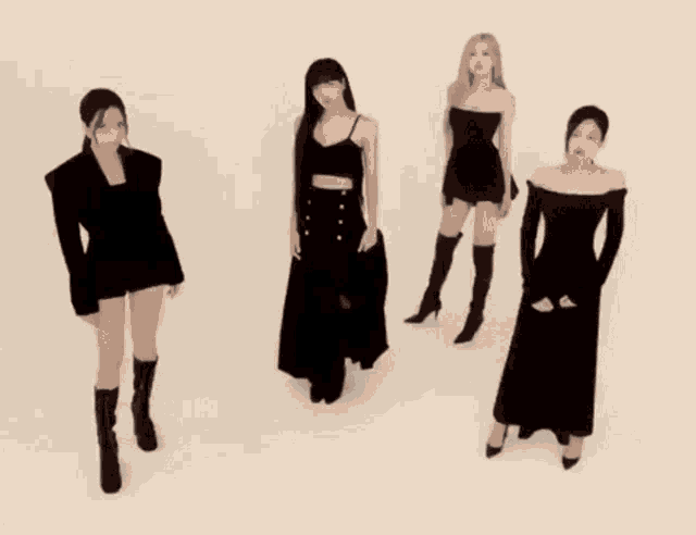 a group of women standing next to each other in black dresses