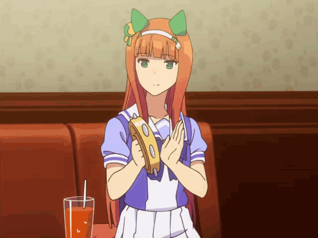 a girl is holding a tambourine and a glass of orange juice in front of her