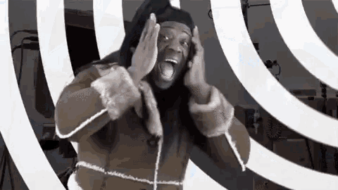 a man in a fur coat is making a funny face while standing in front of a hypnotic background .
