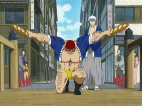 a man in a blue shirt is holding a loaf of bread over his head