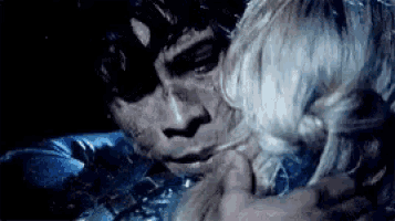 a man and woman are hugging each other in the dark .