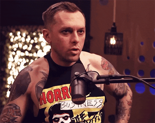 a man wearing a shirt that says horror business on it
