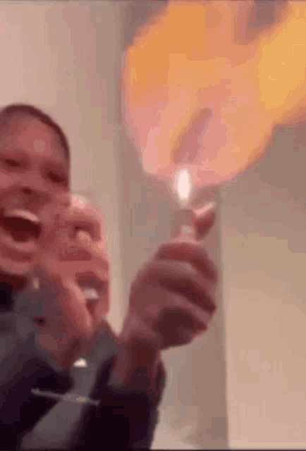 a man is holding a lighter with flames coming out of it in his hands .