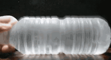 a person is holding an empty plastic bottle on a table .