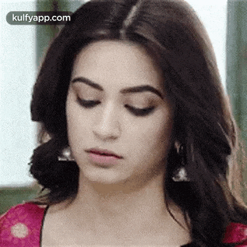 a close up of a woman 's face with her eyes closed wearing earrings .