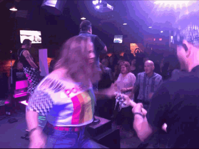 a woman wearing a shirt that says ' i love you ' on it is dancing in a club