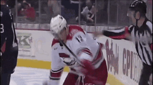 a hockey player with the number 12 on his jersey stands on the ice