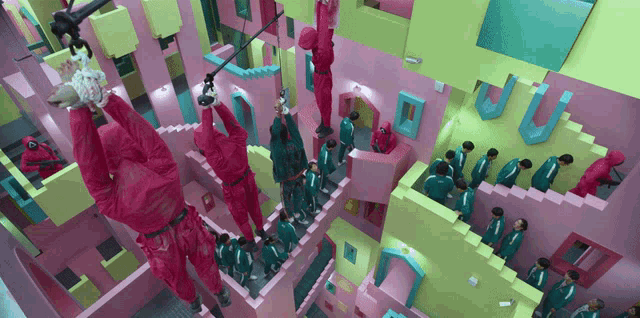 a group of people in pink jumpsuits are playing a game in a pink building