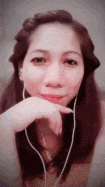 a woman wearing headphones looks at the camera