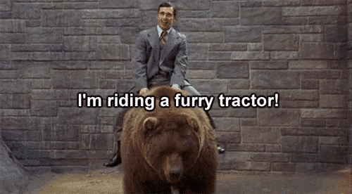 a man in a suit is riding a furry tractor on a bear