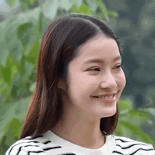 a close up of a woman 's face with a striped shirt on .