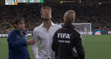 a man wearing a white shirt and a black jacket that says fifa team one