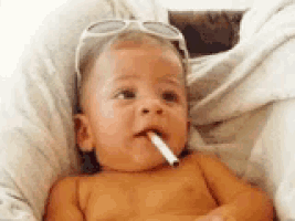 a baby wearing sunglasses is smoking a cigarette in his mouth .