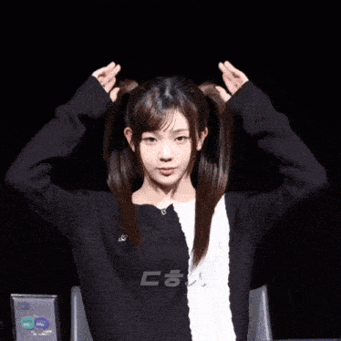 a girl in a black and white sweater holds her hair