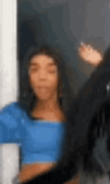 a woman in a blue crop top is taking a selfie .