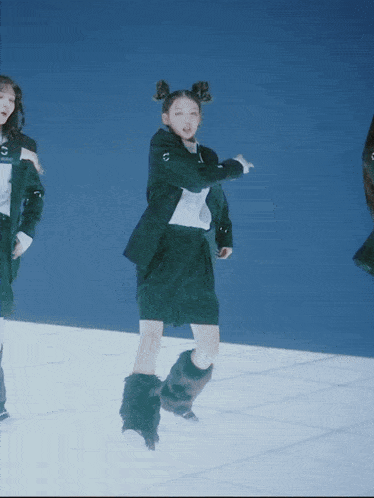 a woman in a black suit is dancing on a white tile floor