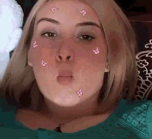 a woman with butterflies on her face making a funny face .