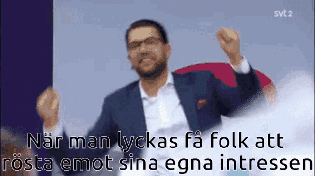 a man in a suit and tie is dancing with the words " när man lyckas fa folk att rosta emot sina egna intressen "