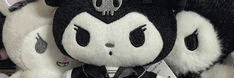 a black and white stuffed animal with a skull on its head and a bow tie .