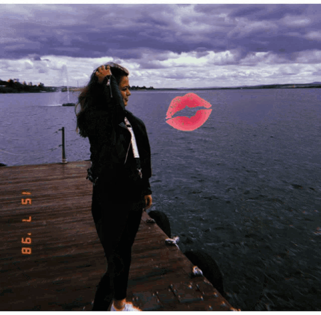 a woman is standing on a dock with a red kiss on her face