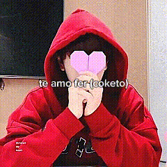 a person wearing a red hoodie is holding a paper heart in front of their eyes .