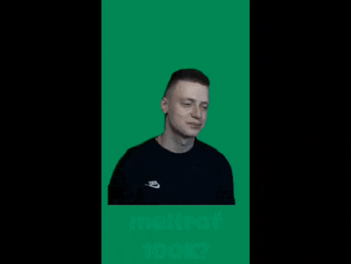a man wearing a black nike shirt is standing in front of a green screen