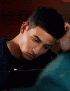 a young man with his hand on his head looks at something