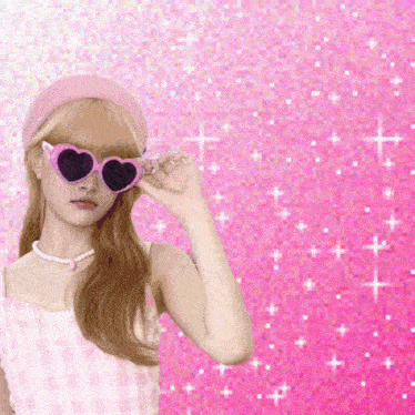 a girl wearing pink heart shaped sunglasses and a pink headband