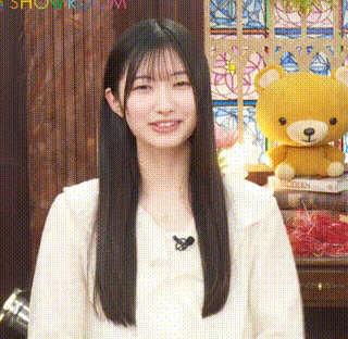 a woman is standing in front of a teddy bear and smiling .
