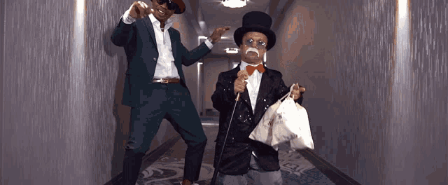 a man in a green suit and a man in a top hat are dancing in a hallway