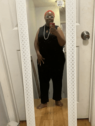 a woman takes a selfie in front of a mirror