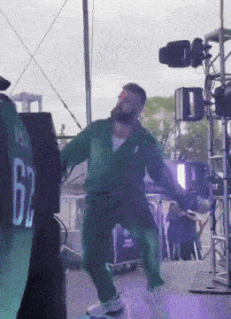 a man in a green jumpsuit with the number 62 on the back