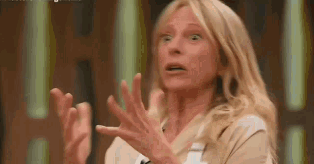 a woman is making a funny face with her hands .