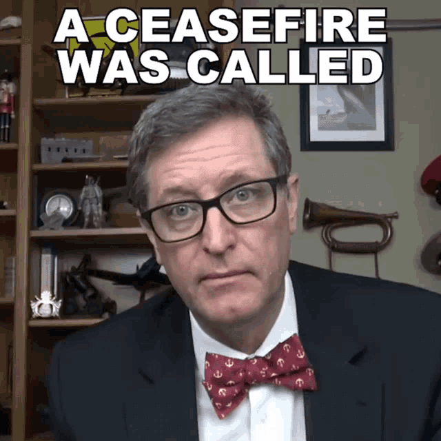 a man wearing glasses and a bow tie says " a ceasefire was called "