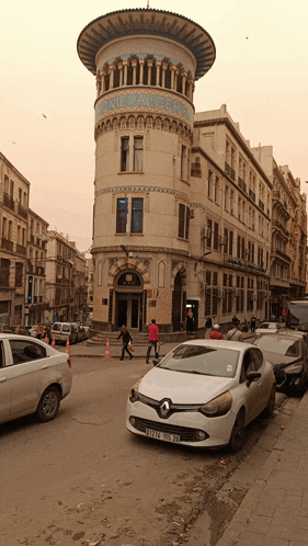 a white car is parked in front of a building that says " banque algerienne "