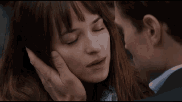 a close up of a man touching a woman 's forehead